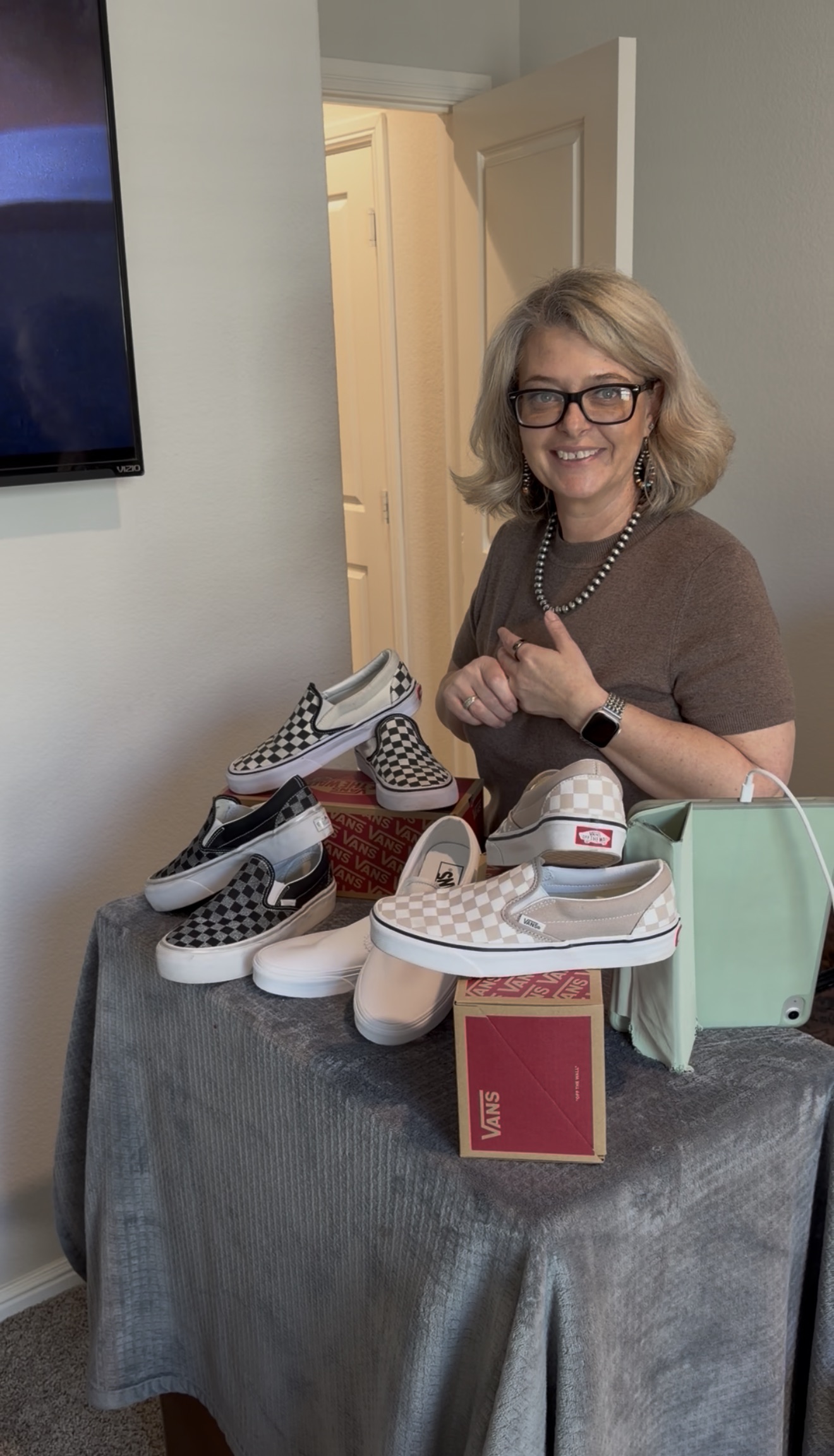 Amber standing behind a table of Vans shoes